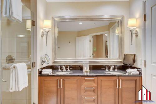 uma casa de banho com 2 lavatórios e um espelho grande em MGM Signature-36-705 F1 Track & Strip View Balcony em Las Vegas