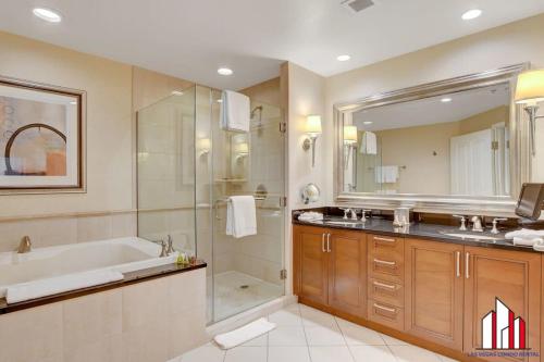 a bathroom with a tub and a shower and a sink at MGM Signature-36-705 F1 Track & Strip View Balcony in Las Vegas