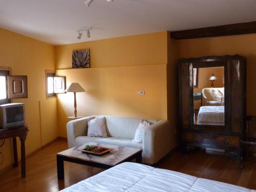Habitación de hotel con sofá y espejo en La Antigua Fonda De Villel en Villel