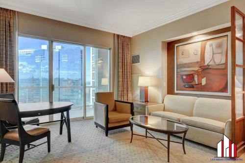 a living room with a couch and a table at MGM Signature-33-711 F1 Track & Strip View Balcony in Las Vegas