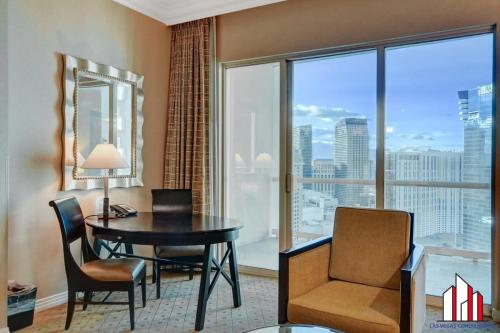 a room with a desk and a table and a window at MGM Signature-33-711 F1 Track & Strip View Balcony in Las Vegas