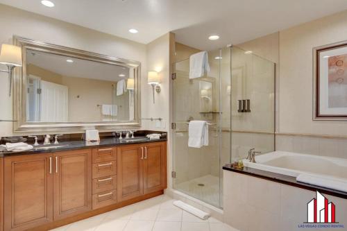 a bathroom with a tub and a sink and a shower at MGM Signature-33-711 F1 Track & Strip View Balcony in Las Vegas