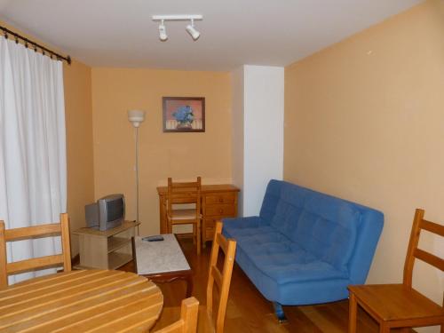 a living room with a blue couch and a table at La Antigua Fonda De Villel in Villel