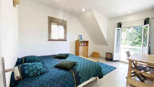 a bedroom with a blue bed and a table at COLIVER - COLIVING A LA RÉUNION in Saint-Pierre