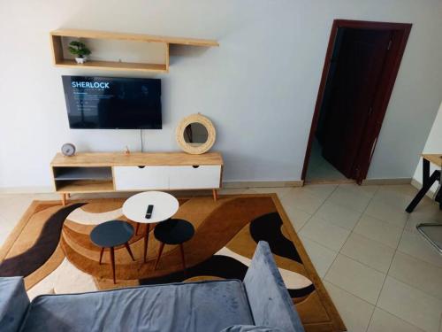 a living room with a couch and a tv at The Lavish Condo -Wandegeya in Kampala
