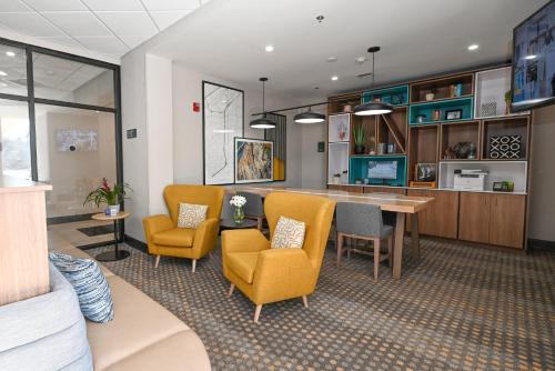 a lobby with chairs and a table and a kitchen at Holiday Inn Cleveland-Mayfield, an IHG Hotel in Mayfield