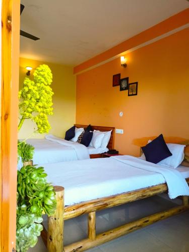 two beds in a room with yellow walls at JMT Eco-Binsar by StayApart in Panuānaula