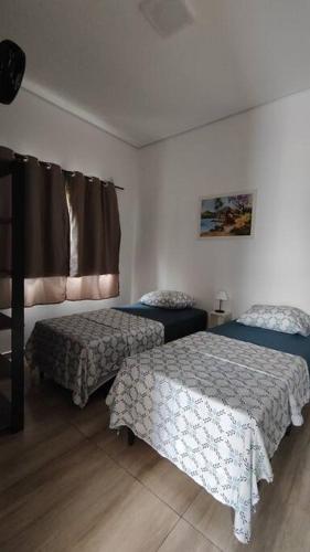 1 dormitorio con 2 camas y ventana en N03 Apartamento para até 4 hóspedes em Jacutinga, en Jacutinga