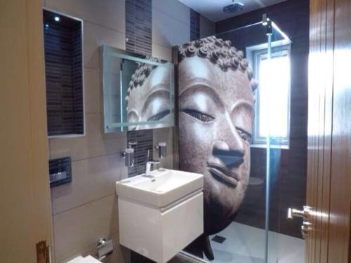 a bathroom with a large head on the wall at Shreyas Cottage in Blackburn