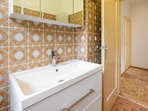 uma casa de banho com um lavatório branco e um espelho. em Apartment in ski area in Kötschach-Mauthen em Laas