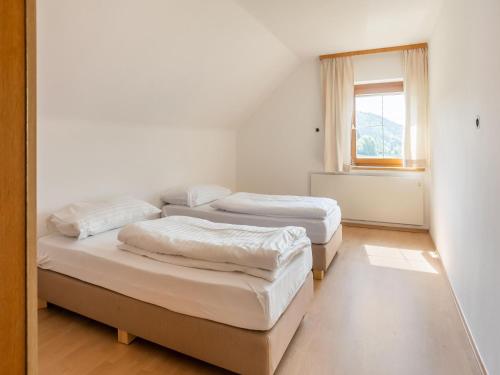 three beds in a room with a window at Apartment in ski area in Kötschach-Mauthen in Laas