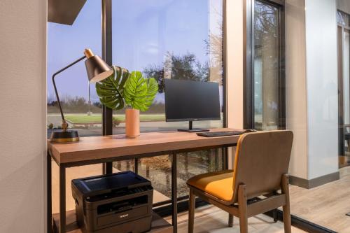 an office with a desk with a computer and a chair at Atwell Suites Austin Airport by IHG in Austin