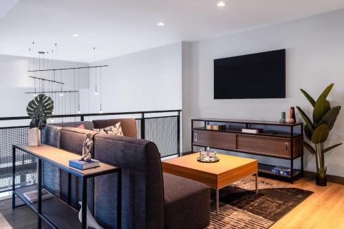 a living room with a couch and a tv at Atwell Suites Austin Airport by IHG in Austin