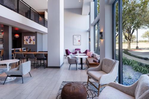 a lobby with chairs and tables in a building at Atwell Suites Austin Airport by IHG in Austin