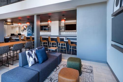 a lobby with a couch and a bar at Atwell Suites Austin Airport by IHG in Austin