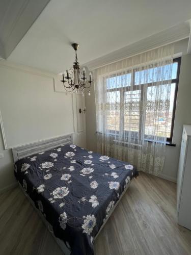 Schlafzimmer mit einem Bett und einem Kronleuchter in der Unterkunft Уютная квартира in Bischkek