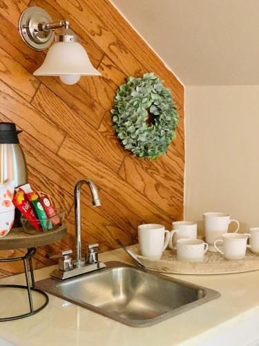 a kitchen sink with cups and a wreath on the wall at Little Hollywood Suite @ The Historic Kanab Inn in Kanab