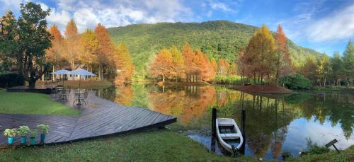 a lake with a dock and a boat on it at Grace Garden Villa in Fengshan