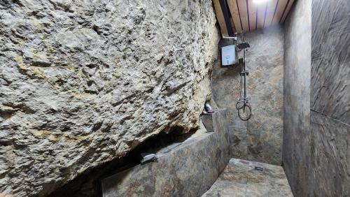 y baño de piedra con ducha y pared de piedra. en Stone and Mountain, en Baguio