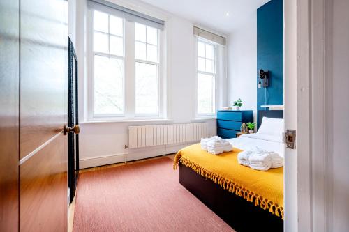 een slaapkamer met een bed en 2 ramen bij Sunny Corner Apartment in Center of London (2) in Londen