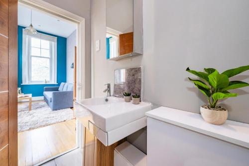 een witte badkamer met een wastafel en een spiegel bij Sunny Corner Apartment in Center of London (2) in Londen