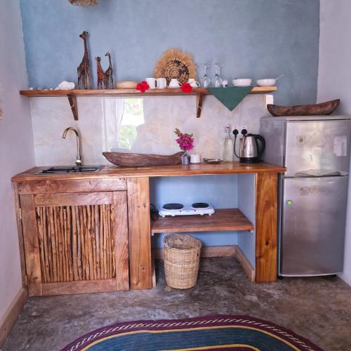a kitchen with a sink and a refrigerator at TIANDE Boutique Hotel in Pwani Mchangani