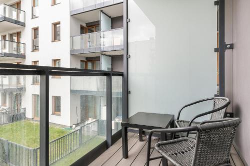 a balcony with a table and chairs and a building at Harmonia Oliwska 25 Apartment with Balcony by Renters in Gdańsk