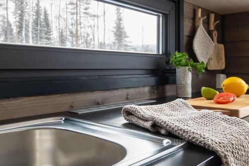 encimera de cocina con fregadero y ventana en HILLA Minimökki with Sauna Fireplace BBQ WiFi Ski Ylläs PetsOK, en Äkäslompolo