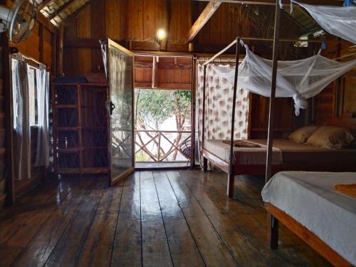 a bedroom with two beds and a door to a porch at GreenBlue Beach Bungalows in Koh Rong Sanloem