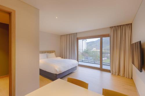 1 dormitorio con cama y ventana grande en Sono Calm Vivaldi Park, en Hongcheon