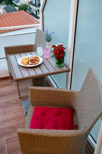a table with a plate of food on a balcony at Suites Rania in Áyios Yeóryios