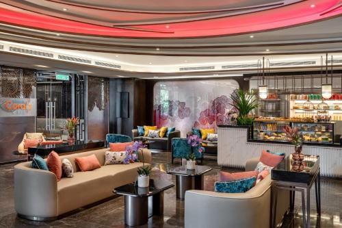 a lobby of a hotel with couches and tables at Imperial Lexis Kuala Lumpur in Kuala Lumpur