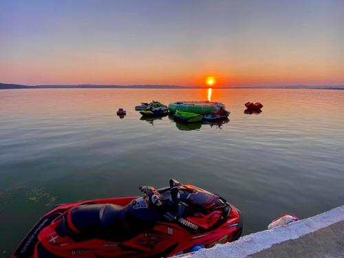 a group of boats sitting on the water at sunset at Pensiunea Leonardo in Moldova Veche