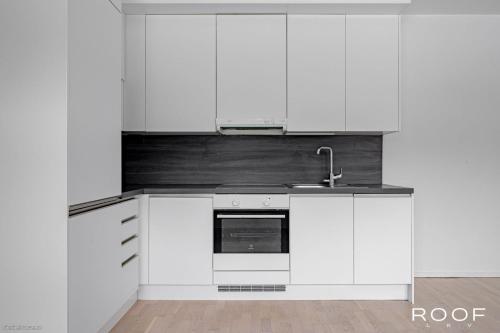 a kitchen with white cabinets and a sink at Cozy and peaceful Dublex in Espoo