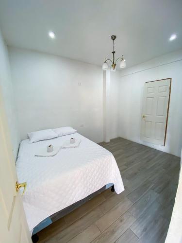 a white bedroom with a bed and a white door at Hotel Royal Vicky in San Juan La Laguna