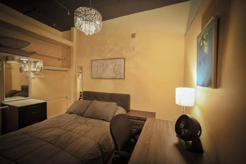 a bedroom with a bed and a table and a lamp at 2 Full Beds, Rogers Place Downtown Central, Memorable 1 Bedroom Condo in Edmonton