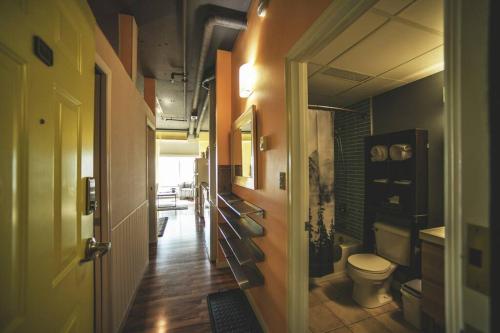 a hallway leading to a bathroom with a toilet at 2 Full Beds, Rogers Place Downtown Central, Memorable 1 Bedroom Condo in Edmonton