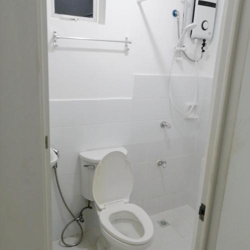 a white bathroom with a toilet and a shower at Ones stop shop Transient House in Butuan