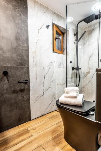 a bathroom with a shower and a sink and a tub at Slona, Heritage Home in Old Town Plovdiv in Plovdiv