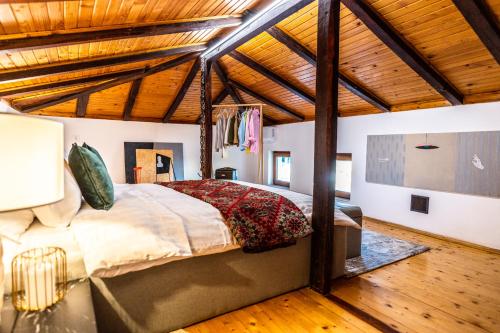 a bedroom with a large bed in a room with wooden ceilings at Slona, Heritage Home in Old Town Plovdiv in Plovdiv
