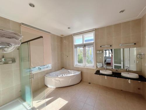 ein großes Badezimmer mit zwei Waschbecken und einer Badewanne in der Unterkunft 3 Bedroom Villa Sealink Mui Ne managed by Vipol in Ấp Phú Tịnh (2)