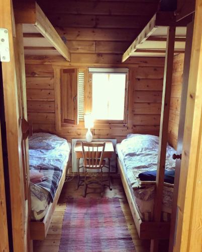 a room with two beds and a table in a cabin at Yngsjö in Yngsjö