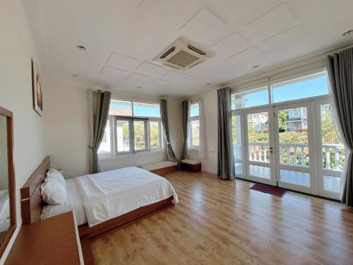 Schlafzimmer mit einem Bett und Glasschiebetüren in der Unterkunft 3 Bedroom Villa Sealink Mui Ne managed by Vipol in Ấp Phú Tịnh (2)