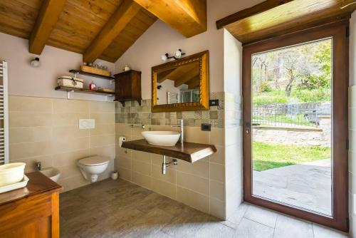a bathroom with a sink and a toilet and a mirror at Fanano - Panoramic Villa by Alterego in Fanano