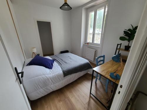 a bedroom with a bed and a wooden table at MARCELINE in Lannion