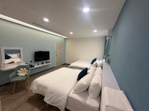 a large bedroom with two beds and a television at Bei Ao Bi Shan Jyu in Dongyin