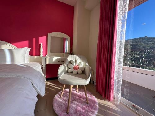a bedroom with a chair and a large window at Bei Ao Bi Shan Jyu in Dongyin