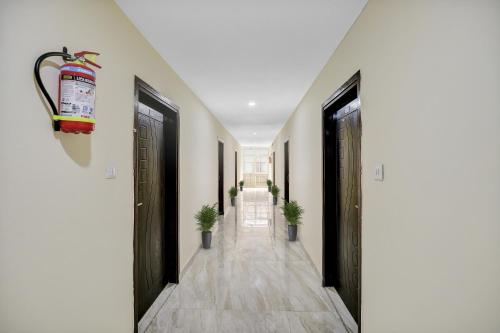 a hallway with black doors and potted plants at OYO Hotel The Bliss in Chandīgarh