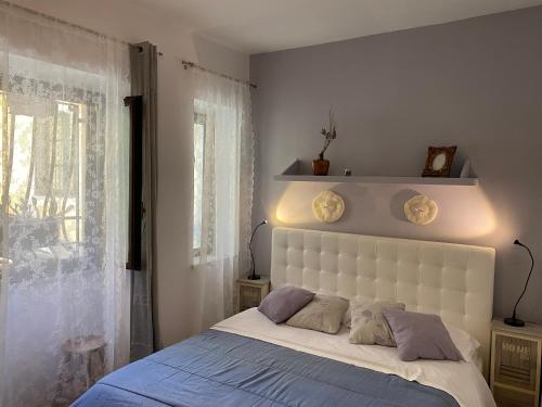 1 dormitorio con 1 cama blanca grande y 2 almohadas en Casa Cajo en Taormina