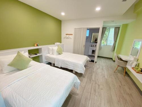 a hotel room with two beds and a mirror at Bei Ao Bi Shan Jyu in Dongyin